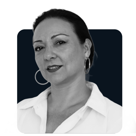 Portrait d'une femme souriante avec des boucles d'oreilles, portant une chemise blanche.
